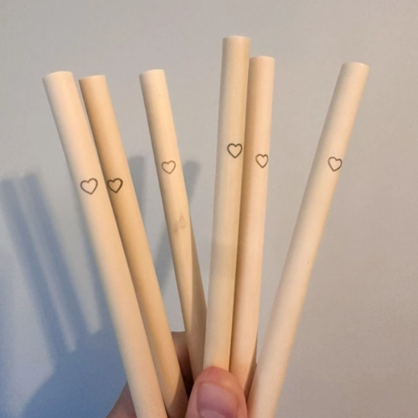 Several bamboo heart straws held in a hand