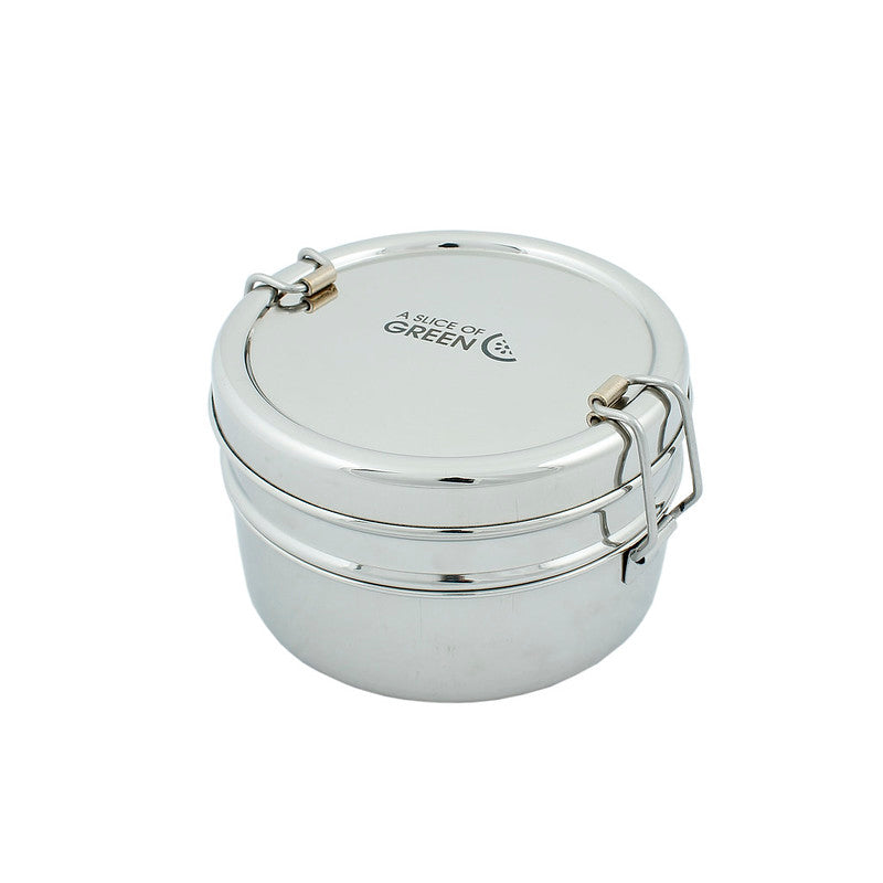 Stainless steel stackable round lunch boxes shown stacked together on a white surface, featuring the brand 'A Slice of Green'.