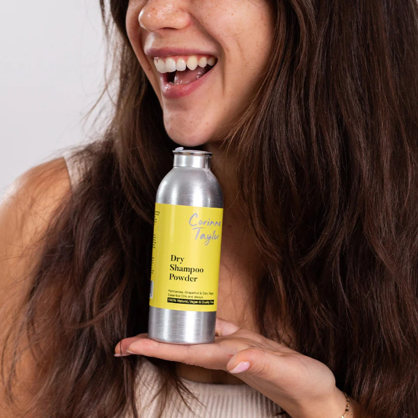 Corinne Taylor dry shampoo powder in aluminium tin shown being held in a hand