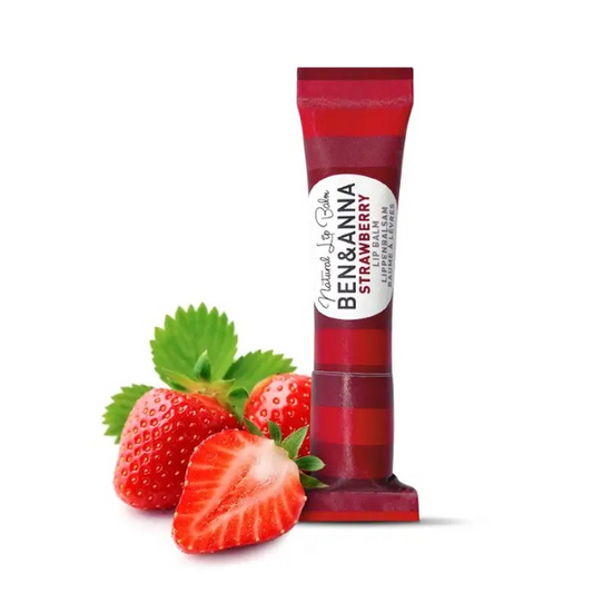 Ben & Anna lip balm in red paper tube packaging in Strawberry, shown alongside some fresh strawberries