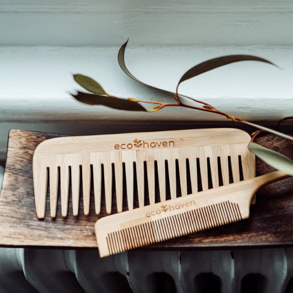 Bamboo long tail comb next to wide tooth comb