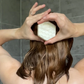 Shower bar for curly hair shown being applied to hair in shower