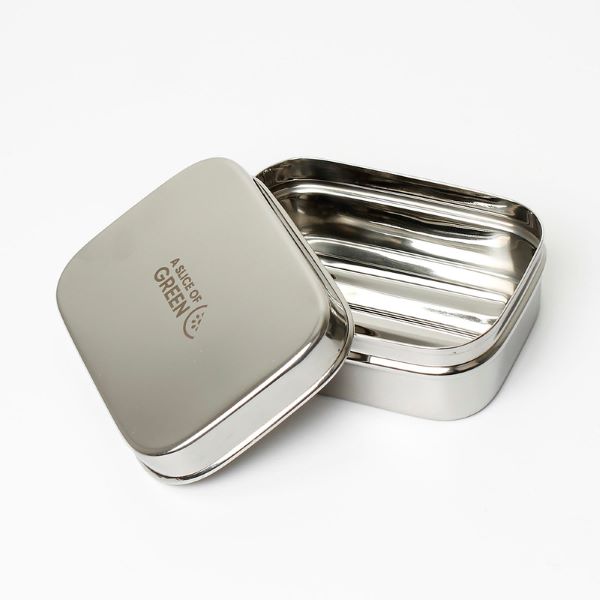 Travel soap or snack tin with lid shown off to see ridged base inside. Lid has logo reading A Slice of Green.