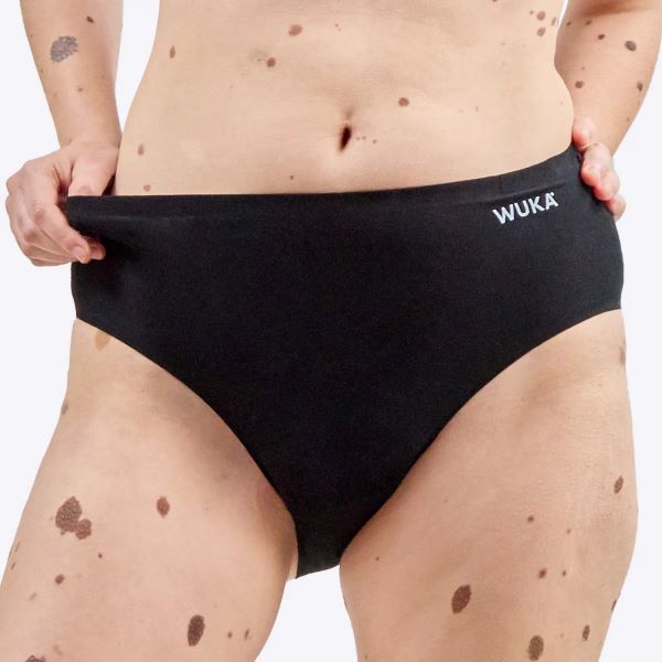 Stretch cotton period pants midi brief seamless stretch shown close up on model with thumb inserted in waistband