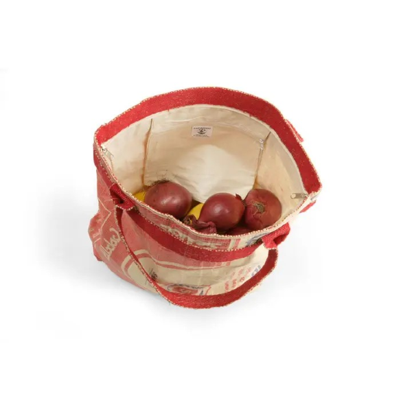 Red recycled cement bag with red straps shown looking inside with red onions in the bag