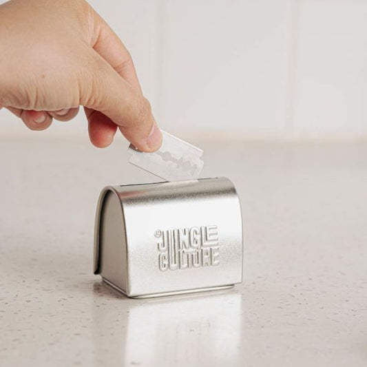 Hand popping a safety razor blade in the storage tin