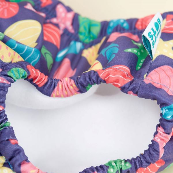 Reusable swim pants side elastic view in Mussel Seashell design (navy blue background with colourful starfish, mussels and shells)