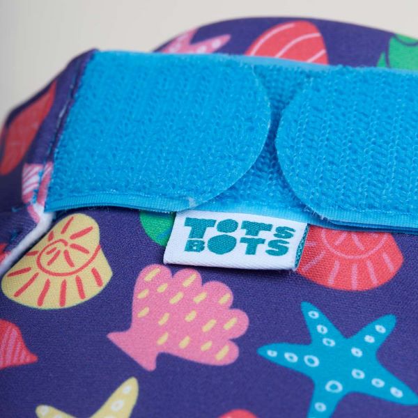 Reusable swim nappy close up view of fastening, in Mussel Seashells design (dark blue background with colourful star fish, mussels and shells)