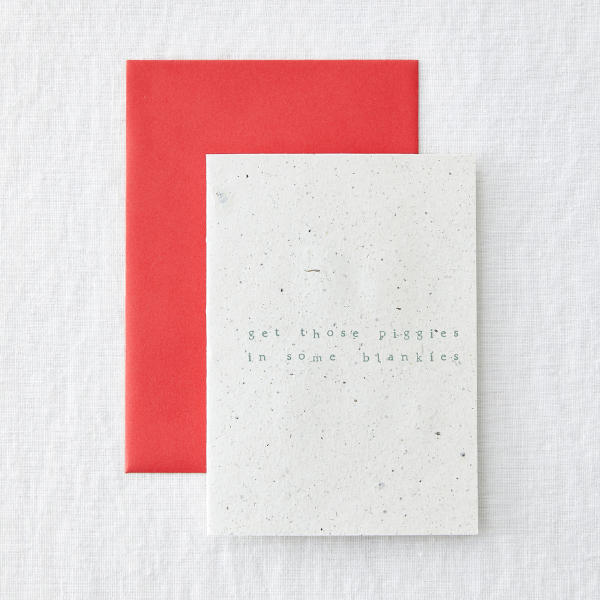 Christmas card saying 'get those piggies in some blankets' with red envelope
