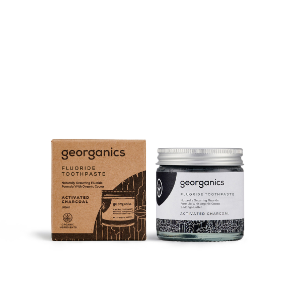 Georganics fluoride toothpaste with activated charcoal in glass jar alongside cardboard box