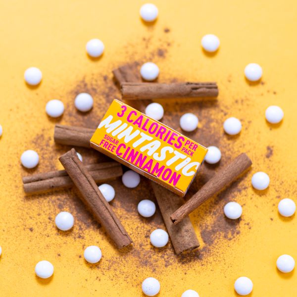 Mintastic sugar-free and vegan mints in cinnamon - boxes with some mints scattered alongside cinnamon sticks