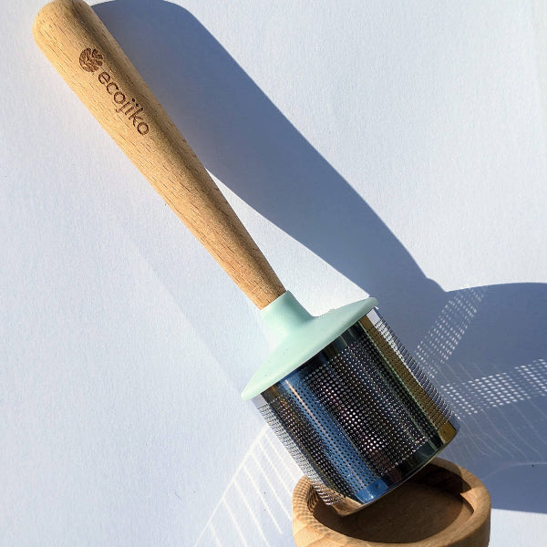 Dunker tea strainer with wooden handle and metal strainer on a white  background