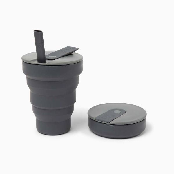 Collapsible cup 16oz shown in charcoal up with flexible straw alongside collapsed 