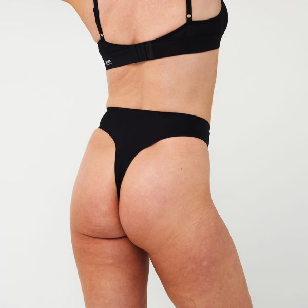 Black stretch thong period pants shown on model from behind