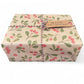 PlanetWrapIt recycled kraft wrapping paper in Christmas mistletoe (brown paper with printed red berries and green leaves) shown on a wrapped parcel with colourful twine and a paper label reading 'Merry Christmas'