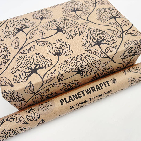 Planet Wrapit eco-friendly kraft wrapping paper with black floral design and PlanetWrapIt paper label shown alongside wrapped parcel.