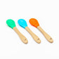 Bamboo and silicone baby weaning spoons in blue, green and orange