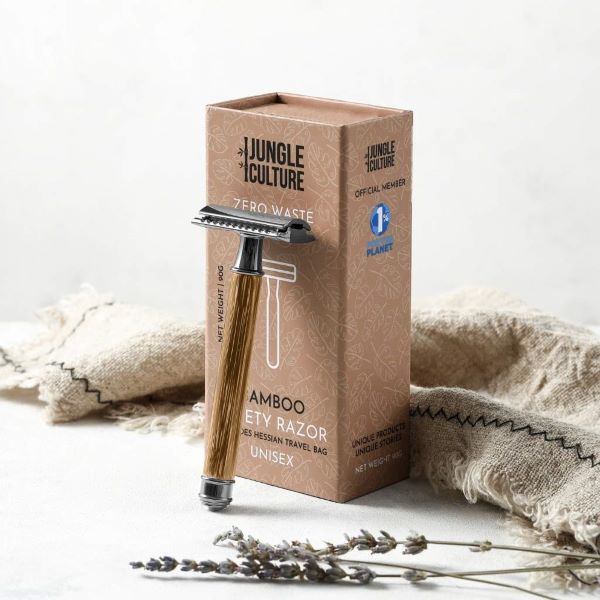 Bamboo safety razor with light wood thin handle shown balanced against cardboard packaging