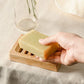 Bamboo soapdish shown with a bar of soap held in a hand