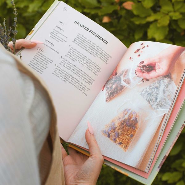 UpCycled beauty Book held in somebody's hand, standing outside, with book open to a page showing how to make drawer freshener