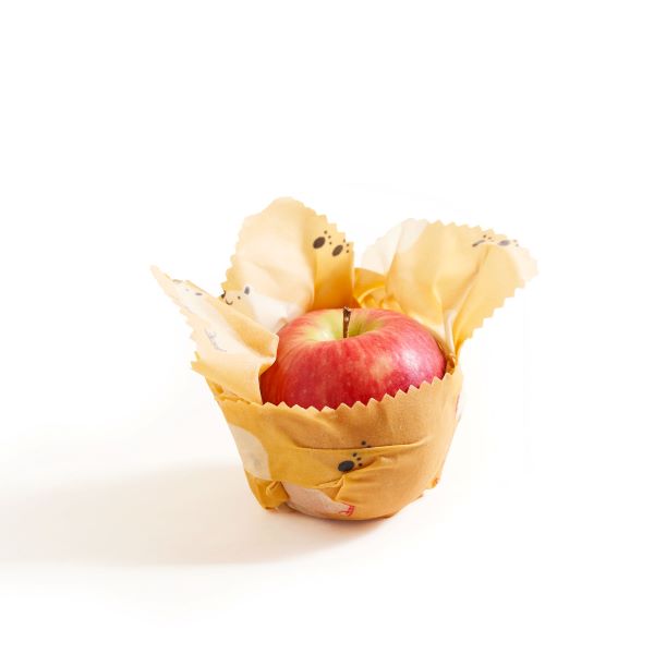 Beeswax wrap in use around a red apple