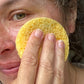 Cellulose facial sponge shown in use on a person's face