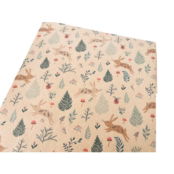 Handmade recycled Christmas paper in Christmas bunnies design, kraft paper background with colourful leaping bunnies and woodland scenes, shown close up