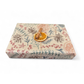 PlanetWrapI recycled kraft wrapping paper in Christmas dried orange (brown background with images of dried oranges, pine cones, foliage) shown on a wrapped parcel with dried orange and cinnamon