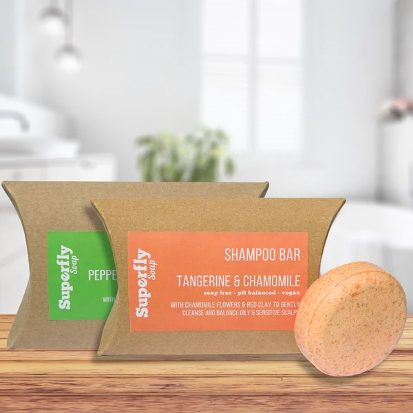 Cleansing shampoo bar next to cardboard packaging