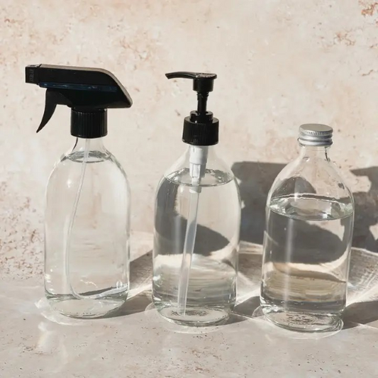 Selection of clear glass reusable bottles shown with both spray and pump lid top