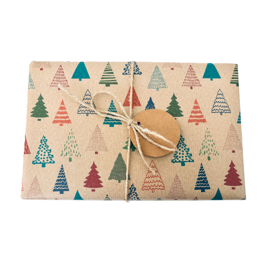 Parcel wrapped in recycled handmade wrapping paper in Colourful Christmas Trees design (brown kraft background with colourful Christmas trees in a hand-drawn style) tied with brown twine 