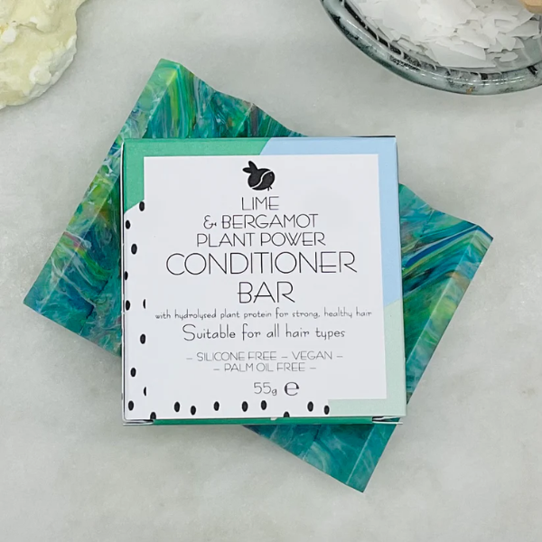 Conditioner bar for curly hair shown with cardboard packaging on a soap dish