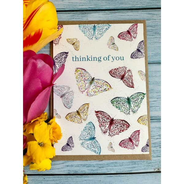 Eco birthday card, white background with lots of watercolour butterflies with the words "thinking of you" 
