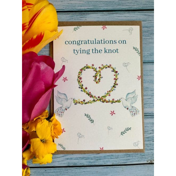 Eco-friendly card by eco artist Jen Winnett reading "congratulations on tying the knot" with watercolour painted doves with flowers in a heart shape