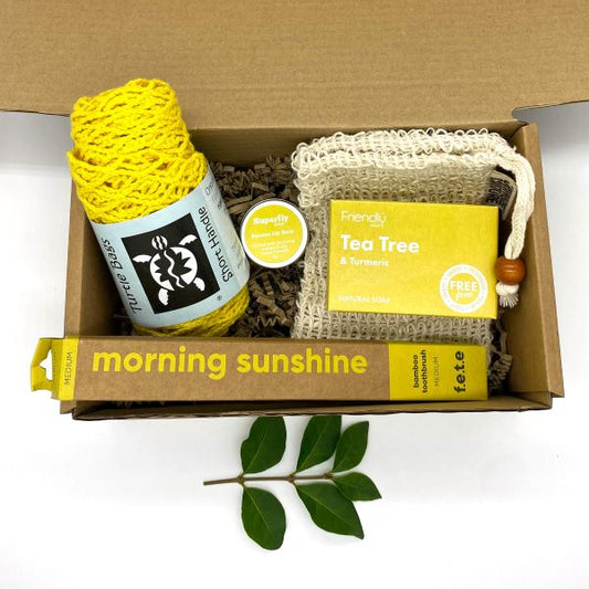 Eco-friendly starter gift set inside cardboard packaging with contents inside in bright shades of yellow