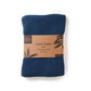 Knitted cotton hand towel in Ocean blue shown in kraft paper packaging
