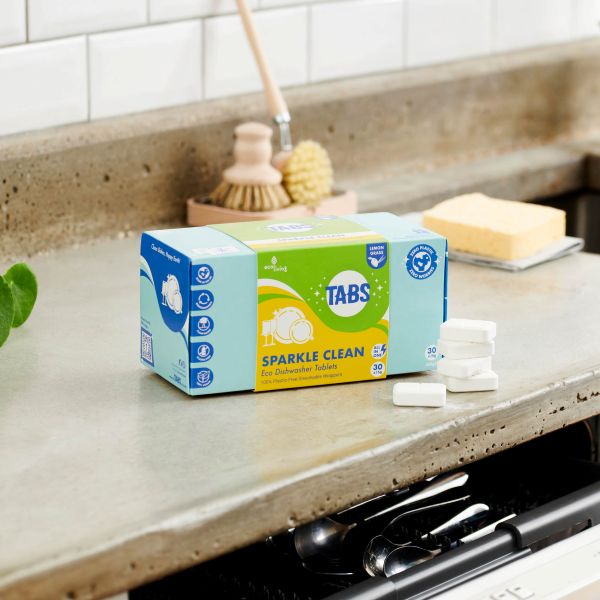 Box of Tabs Sparkle Clean on a kitchen counter with cleaning tools in the background