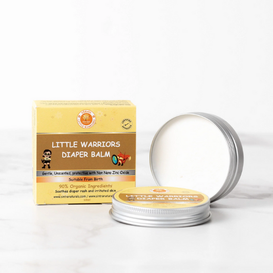 Little Warriors diaper balm in aluminium tin shown with lid off and balm inside, next to cardboard box packaging