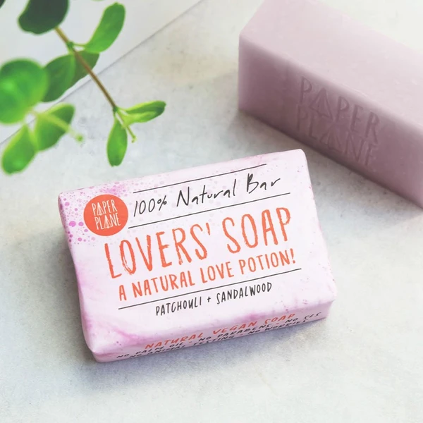 Wrapped Lovers' soap bar, with text on the paper wrapping reading "100% Natural bar, Lovers' Soap, a natural love potion! Patchouli & sandalwood"