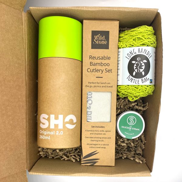 Eco-friendly gift set for out and about in green shown with items inside cardboard packaging box with kraft paper