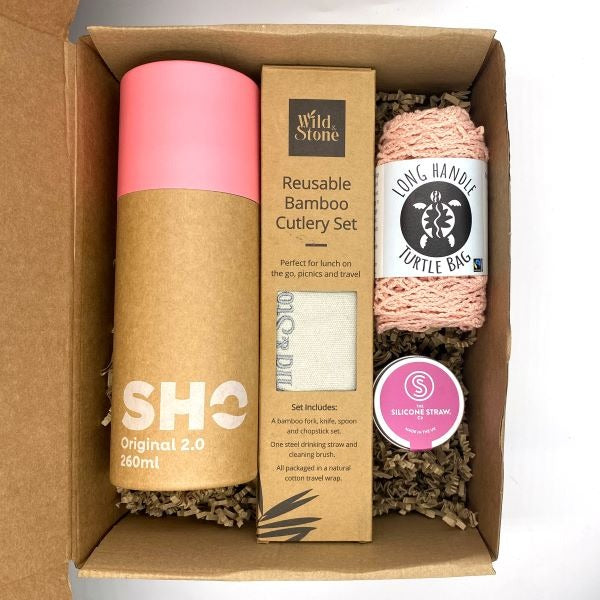 Eco-friendly gift set for out and about in pink shown with items inside cardboard packaging box with kraft paper