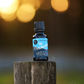 The Outdoorsman bear oil in glass bottle sitting atop a wooden post