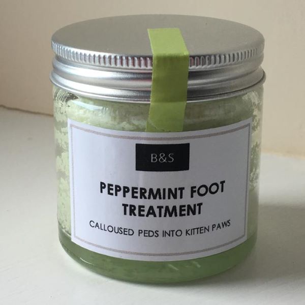 Peppermint foot treatment in glass jar with aluminium lid, paper label reads "Calloused peds into kitchen paws")