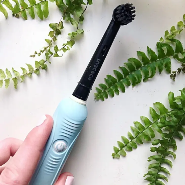 Two Live Coco recyclable electric toothbrush heads shown in use on an electric toothbrush