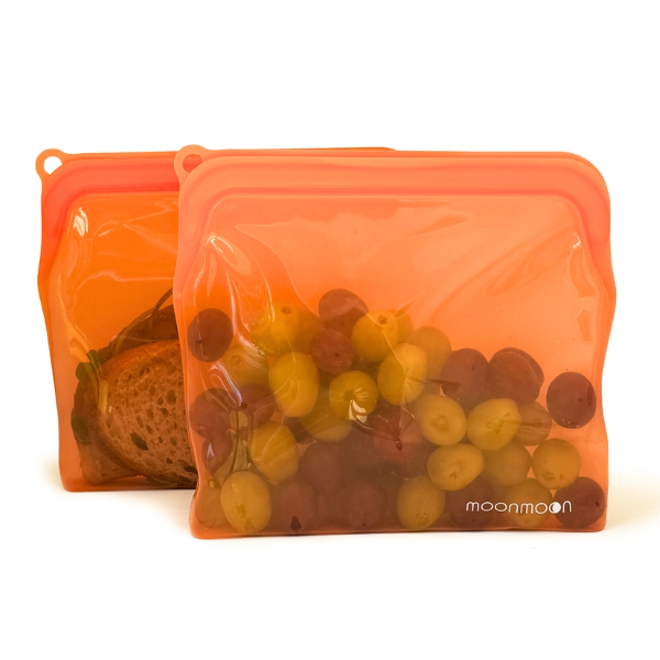 Reusable silicone food bags in large size pack of 2 shown side by side with grapes and a sandwich inside