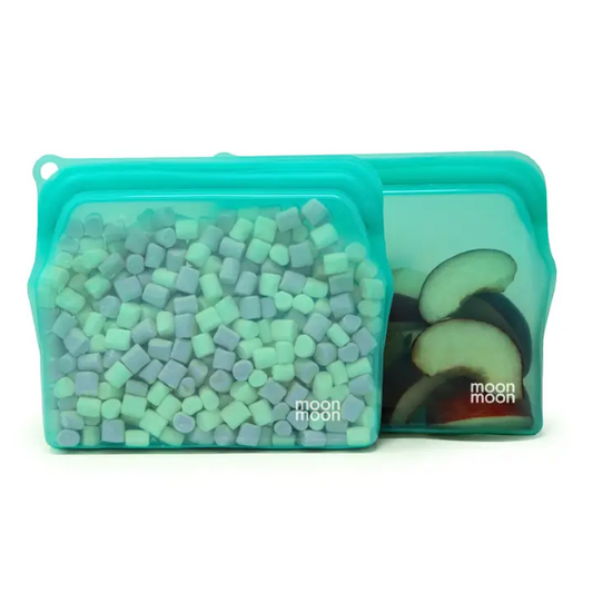 Reusable silicone food bags in medium size pack of 2 shown side by side with marshmallows and fruit slices inside