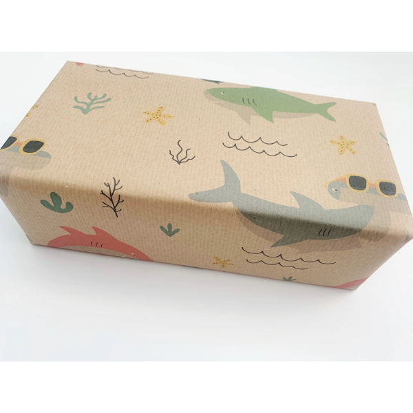 Eco-friendly recyclable wrapping paper in shark design (brown paper with colourful sharks in the sea) shown on a wrapped box