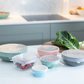 Set of 6 reusable silicone lids shown covering various bowl sizes