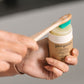 Toothsoap in someone's hand with toothbrush swirling over the top