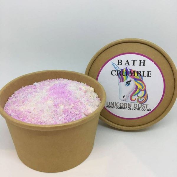Bain and Savon bath crumble in Unicorn dust shown in paper pot with lid off, pink and purple crumble inside